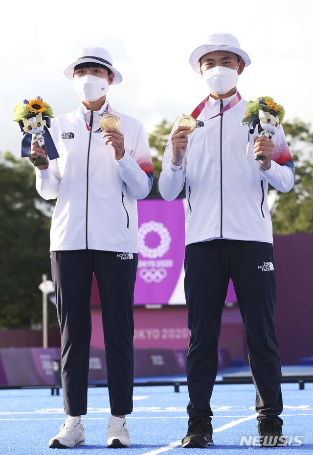 [도쿄(일본)=뉴시스] 최진석 기자 = 대한민국 양궁 대표팀 안산과 김제덕이 24일 오후 일본 도쿄 유메노시마 양궁장에서 열린 2020 도쿄올림픽 양궁 남녀혼성단체전에서 우승을 차지한 뒤 금메달을 들고 포즈를 취하고 있다. 2021.07.24. myjs@newsis.com