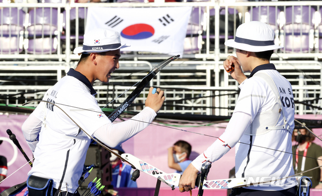 [도쿄(일본)=뉴시스] 최진석 기자 = 대한민국 양궁 대표팀 안산과 김제덕이 24일 오후 일본 도쿄 유메노시마 양궁장에서 열린 2020 도쿄올림픽 양궁 남녀혼성단체전 결승에 참가해 세트포인트를 얻은 뒤 기뻐하고 있다. 2021.07.24. myjs@newsis.com