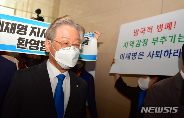 [광주=뉴시스] 류형근 기자 = 더불어민주당 대선주자인 이재명 경기지사가 25일 오전 광주 서구 민주당광주시당 대회의실에서 지역기자간담회를 하기 위해 입장하고 있는 가운데 지지자와 반대단체가 피켓을 들고 있다. 2021.07.25. hgryu77@newsis.com