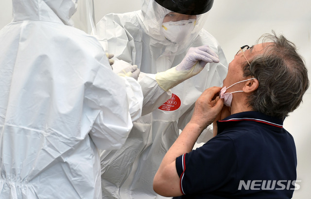 [대구=뉴시스] 이무열 기자 = 대구지역 코로나19 확진자가 69명으로 집계된 25일 오전 대구 수성구 보건소 코로나19 선별진료소에서 의료진이 검체 채취를 하고 있다. 2021.07.25. lmy@newsis.com