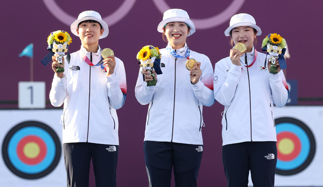 [도쿄(일본)=뉴시스] 최진석 기자 = 대한민국 양궁 대표팀 안산(왼쪽부터), 장민희, 강채영이 25일 오후 일본 도쿄 유메노시마 양궁장에서 열린 2020 도쿄올림픽 양궁 여자단체전 금메달을 획득, 시상식에서 시상대 올라 금메달과 트로피를 들어보이고있다. 2021.07.25. myjs@newsis.com