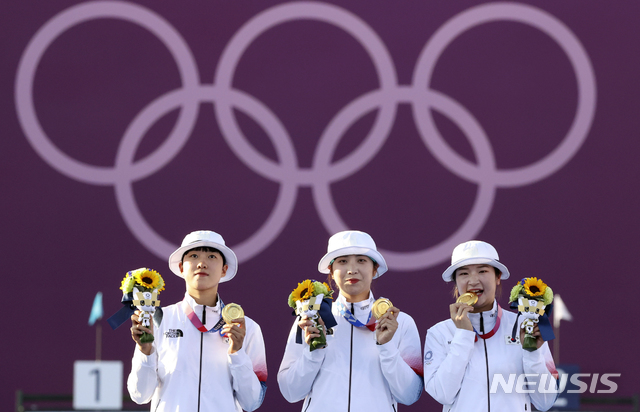 [도쿄(일본)=뉴시스] 최진석 기자 = 대한민국 양궁 대표팀 안산, 장민희, 강채영이 25일 오후 일본 도쿄 유메노시마 양궁장에서 열린 2020 도쿄올림픽 양궁 여자단체전 우승, 시상식에서 금메달을 목에 걸고 포즈를 취하고 있다. 2021.07.25. myjs@newsis.com