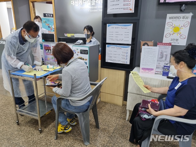 [청주=뉴시스] 55~59세 대상 백신 예방접종이 시작된 26일 충북 청주의 한 병원에서 50대 시민이 문진표를 작성하고 있다. 이번 50대 대규모 백신 접종은 26일부터 8월 14일까지 도내 만 55~59세 11만1960명을 대상으로 우선 진행된다. 다음달 16일부터 28일까진 만 50~54세가 백신을 맞는다. 2021.07.26. hugahn@newsis.com 