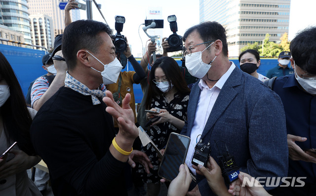 [서울=뉴시스] 홍효식 기자 = 광화문 광장 재구조화 공사를 위해 '세월호 기억공간' 철거를 앞둔 26일 서울 종로구 광화문 광장 세월호 기억공간 앞에서 서울시 김혁(오른쪽) 총무과장이 4.16연대 김선우 사무처장에게 자진 철거를 요구하고 있다. 2021.07.26. yesphoto@newsis.com