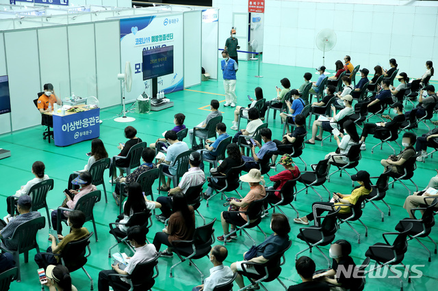 [서울=뉴시스] 조수정 기자 = 만 55~59세(1962~1966년생) 코로나19 백신 접종이 시작된 26일 서울 동대문구체육관 코로나19 예방접종센터에서 사전 예약자들이 백신을 맞은 뒤 이상반응을 모니터링하기 위해 대기하고 있다. 55~59세는 수도권 화이자, 비수도권 모더나를 접종한다. 2021.07.26. chocrystal@newsis.com