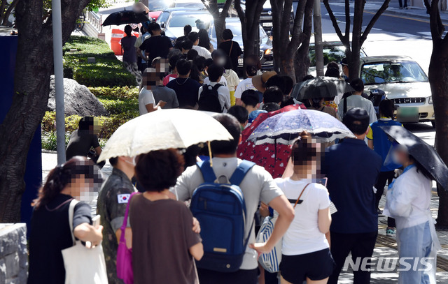 [부산=뉴시스] 하경민 기자 = 부산지역 코로나19 확산세가 심상치 않은 가운데 지난 26일 오전 부산 남구보건소 선별진료소를 찾은 시민들이 진단검사를 받기 위해 길게 줄을 선 채 차례를 기다리고 있다. 이날 해당 보건소 주변으로 검사 대기 줄이 100m 가량 이어졌다. 2021.07.26. yulnetphoto@newsis.com