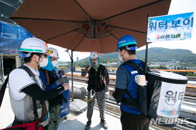 [서울=뉴시스] 그랜드앰배서더 서울 리모델링 현장에서 시원한 얼음물을 제공하고 있는 워터보이 모습. (사진=쌍용건설 제공)