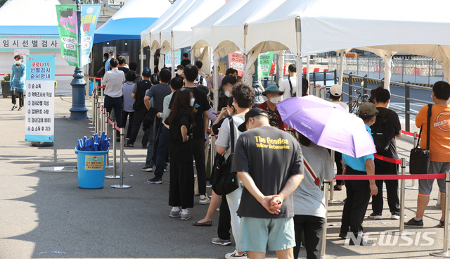 [서울=뉴시스] 조수정 기자 = 코로나19 신규확진자가 1365명 발생한 27일 서울 중구 서울역광장 코로나19 임시선별검사소에서 시민들이 이른 아침부터 검사를 받기 위해 긴 줄을 이루며 대기하고 있다. 2021.07.27. chocrystal@newsis.com