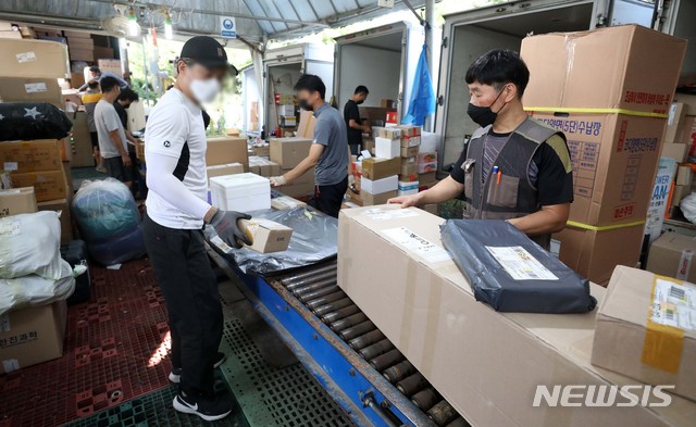 [구리=뉴시스]김선웅 기자 = 연일 폭염이 계속된 지난달 28일 오전 경기 구리시 갈매동의 한 택배대리점에서 박창규 씨(오른쪽)을 비롯한 택배기사들이 분류작업을 하고 있다. 2021.07.28.