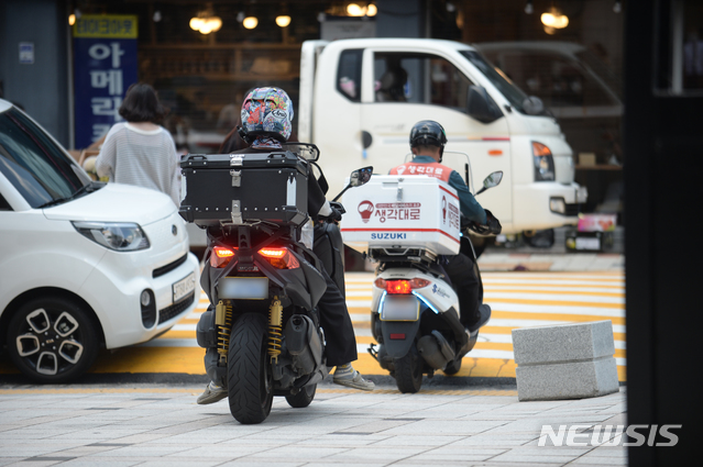 [광주=뉴시스] 김혜인 기자 = 33.9도를 기록한 28일 오후 광주 동구 서석동 한 도로에서 배달 기사들이 도로를 달리고 있다. 2021.07.28.hyein0342@newsis.com