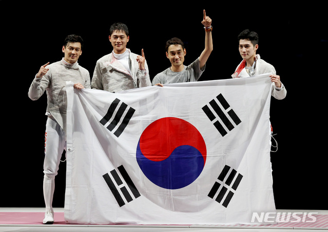 [지바(일본)=뉴시스] 최진석 기자 = 대한민국 펜싱 대표팀이 28일 오후 일본 지바 마쿠하리 메세 B홀에서 열린 도쿄올림픽 펜싱 남자 사브르 단체 결승전 이탈리아와의 경기에서 승리해 금메달을 결정지은 뒤 태극기를 들며 기뻐하고 있다. 2021.07.28. myjs@newsis.com