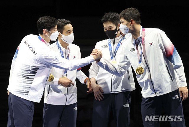 [지바(일본)=뉴시스] 최진석 기자 = 대한민국 펜싱 대표팀 구본길과 김정환, 김준호, 오상욱이 28일 오후 일본 지바 마쿠하리 메세 B홀에서 열린 도쿄올림픽 펜싱 남자 사브르 단체 결승전 이탈리아와의 경기에서 승리를 거두며 금메달을 차지한 뒤 시상식에서 서로 인사를 하고 있다. 2021.07.28. myjs@newsis.com
