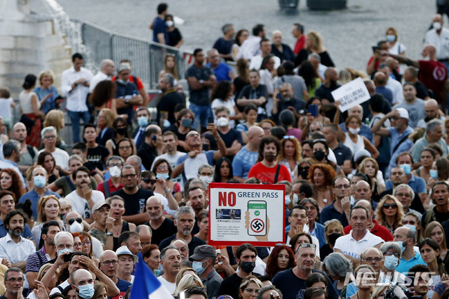 [로마=AP/뉴시스] 28일(현지시간) 이탈리아 로마에서 코로나19 '그린 패스' 제도 의무화에 반대하는 사람들이 시위하고 있다. 이탈리아 정부는 8월 6일부터 이른바 '그린 패스'의 사용을 의무화하는 법령을 승인했다. 이에 따라 식당, 스포츠 경기장 등에 입장할 때 지난 9개월 동안 최소 1회 이상의 백신을 접종했거나 최근 6개월 사이 코로나19에서 회복했음 등을 입증하는 '그린 패스'를 소지해야 한다. 2021.07.29.