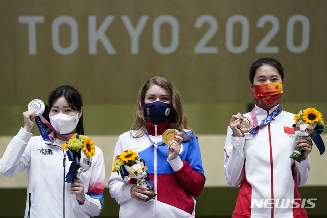 Silver medalist Minjung Kim, left, of South Korea, gold medalist Vitalina Batsarashkina, of the Russian Olympic Committee, and bronze medalist Xiao Jiaruixuan, of China, celebrate after the women's 25-meter pistol at the Asaka Shooting Range in the 2020 Summer Olympics, Friday, July 30, 2021, in Tokyo, Japan. (AP Photo/Alex Brandon)