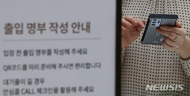 [서울=뉴시스] 권창회 기자 = 백화점과 대형마트에서 안심콜·QR코드 의무화 시행 첫 날인 30일 오후 서울 중구 롯데백화점 본점에서 고객이 QR코드 체크인을 위해 핸드폰을 만지고 있다. 2021.07.30. kch0523@newsis.com