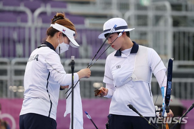 [도쿄(일본)=뉴시스] 최진석 기자 = 대한민국 양궁 대표팀 안산이 30일 일본 도쿄 유메노시마 양궁장에서 열린 2020 도쿄올림픽 양궁 여자 개인 결승 러시아올림픽위원회 옐레나 오시포바와의 경기에서 류수정 감독과 화살을 살펴보고 있다. 2021.07.30. myjs@newsis.com