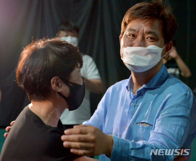 [광주=뉴시스] 변재훈 기자 = '양궁 전사' 안산의 어머니 구명순씨가 30일 광주 광산구 광주여자대학교 유니버시아드 체육관 응원현장에서 안산을 지도한 김성은 광주여대 양궁팀 감독에게 감사의 포옹을 하고 있다. 광주여대에 재학 중인 안산은 도쿄올림픽 양궁 혼성·여자 단체전 금메달에 이어 개인전까지 3관왕을 달성했다. 2021.07.30. wisdom21@newsis.com