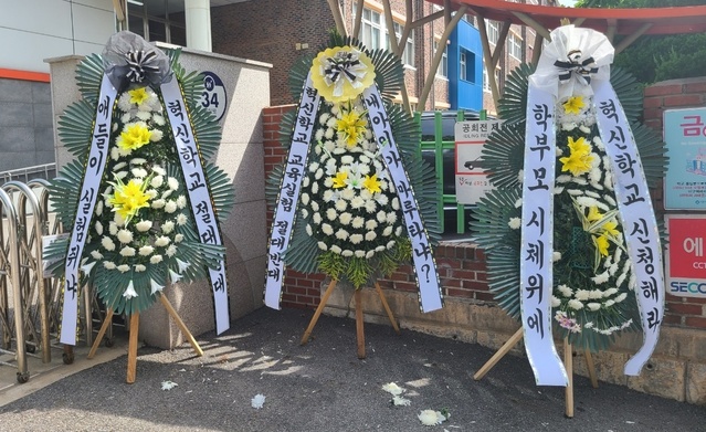 [수원=뉴시스] 혁신학교 반대하는 학부모와 지역주민들이 학교 앞에 보낸 근조화환. 2021.7.31. (사진=독자제공) *재판매 및 DB 금지