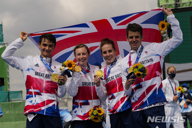 [도쿄=AP/뉴시스]제시카 러먼스, 조너선 브라운리, 조지아 타일러-브라운, 알렉스 이가 출전한 영국은 31일 일본 도쿄 오다이바 해상공원에서 열린 '2020 도교올림픽' 트라이애슬론 혼성 계주에서 1시간23분41초로 금메달을 목에 걸었다. 2021.07.31.