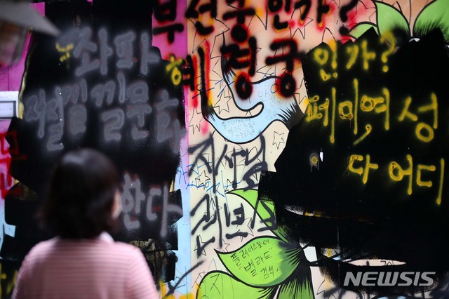 [서울=뉴시스] 김선웅 기자 = 서울 종로구의 한 서점 외벽에 '쥴리의 남자들'로 불리는 그림 (윤석열 전 검찰총장의 부인 김건희 씨 비방 내용의 벽화)이 그려져 논란이 되고 있다. 윤석열 전 검찰총장 측은 법적 대응에 나서지는 않겠다는 입장을 밝혔다. 일부 보수단체는 검은색 페인트를 덧칠하고 여권 인사들을 비방하는 내용의 낙서를 남기기도 했다. 1일 서울 종로구 관철동에 위치한 서점 외벽의 모습. 2021.08.01. mangusta@newsis.com