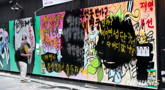 [서울=뉴시스] 김선웅 기자 = 서울 종로구의 한 서점 외벽에 '쥴리의 남자들'로 불리는 그림 (윤석열 전 검찰총장의 부인 김건희 씨 비방 내용의 벽화)이 그려져 논란이 되고 있다. 윤석열 전 검찰총장 측은 법적 대응에 나서지는 않겠다는 입장을 밝혔다. 일부 보수단체는 검은색 페인트를 덧칠하고 여권 인사들을 비방하는 내용의 낙서를 남기기도 했다. 1일 서울 종로구 관철동에 위치한 서점 외벽의 모습. 2021.08.01. mangusta@newsis.com