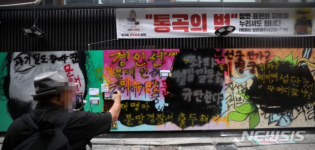 [서울=뉴시스] 김선웅 기자 = 서울 종로구의 한 서점 외벽에 '쥴리의 남자들'로 불리는 그림 (윤석열 전 검찰총장의 부인 김건희 씨 비방 내용의 벽화)이 그려져 논란이 되고 있다. 윤석열 전 검찰총장 측은 법적 대응에 나서지는 않겠다는 입장을 밝혔다. 일부 보수단체는 검은색 페인트를 덧칠하고 여권 인사들을 비방하는 내용의 낙서를 남기기도 했다. 1일 서울 종로구 관철동에 위치한 서점 외벽의 모습. 2021.08.01. mangusta@newsis.com