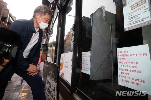 [서울=뉴시스] 국회사진기자단 = 최재형 전 감사원장이 1일 오후 서울 용산구 이태원 세계음식거리에서 휴업한 가게에 붙어있는 문구를 읽고있다. 2021.08.01. photo@newsis.com