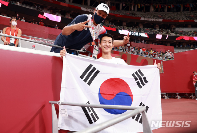 [도쿄(일본)=뉴시스] 이영환 기자 = 육상 국가대표 우상혁이 1일 오후 도쿄 올림픽스타디움에서 열린 2020 도쿄올림픽 남자 높이뛰기 결승전 경기를 마친 후 태극기를 들고 기뻐하고 있다. 우상혁은 2.35m를 성공해 한국 신기록을 세우며 4위로 경기를 마무리 했다. 2021.08.01. 20hwan@newsis.com