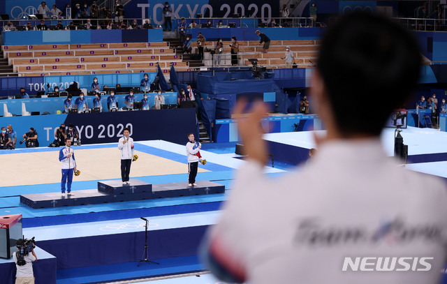 [도쿄(일본)=뉴시스] 최진석 기자 = 신재환이 2일 일본 도쿄 아리아케 체조경기장에서 열린 '2020 도쿄올림픽' 남자 도마 결승에서 금메달을 획득한 뒤 시상식에서 메달을 보이고 있다. 양학선(오른쪽) 선수가 박수를 보내고 있다. 2021.08.02. myjs@newsis.com