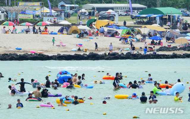 [제주=뉴시스] 우장호 기자 = 한낮 기온이 33도를 웃도는 등 무더운 날씨를 보이는 4일 오후 제주시 애월읍 곽지해수욕장을 찾은 피서객들이 물놀이를 하며 더위를 식히고 있다. 2021.08.04. woo1223@newsis.com