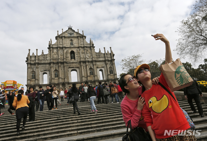 [마카오=AP/뉴시스] 마카오가 관광객 유치를 위해 12만장의 무료 항공권을 제공하기로 했다고 마카오 일보 등 현지 언론이 4일 보도했다. 사진은 마카오의 유명 관광지인 세인트 폴 성당 앞에서 관광객들이 사진을 찍는 모습. 2023.02.04