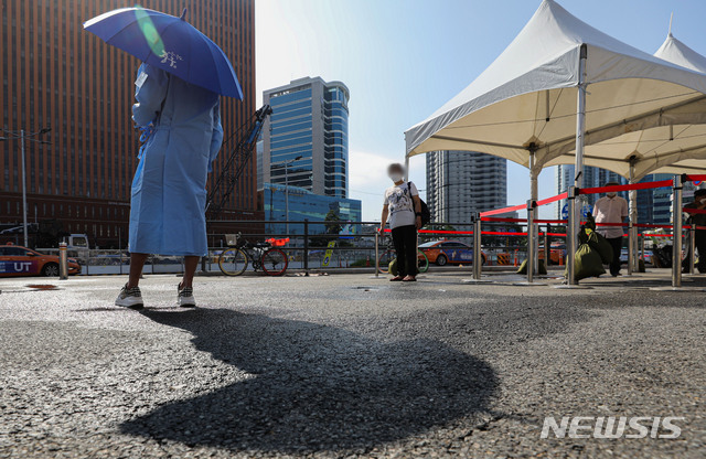 [서울=뉴시스] 권창회 기자 = 코로나19 신규 확진자가 1,776명으로 집계된 5일 오전 서울 중구 서울역 광장 임시선별검사소에서 육군 장병이 양산을 쓰고 안내를 하고 있다. 2021.08.05. kch0523@newsis.com