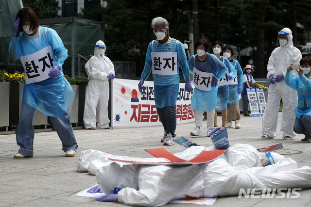 [서울=뉴시스] 홍효식 기자 = 민주노총 공공운수노조 의료연대 조합원들이 지난 5일 오전 서울시청 앞에서 코로나19 감염병상 간호인력 기준마련을 요구하며 방호복을 입고 퍼포먼스를 하고 있다. 2021.08.05. yesphoto@newsis.com