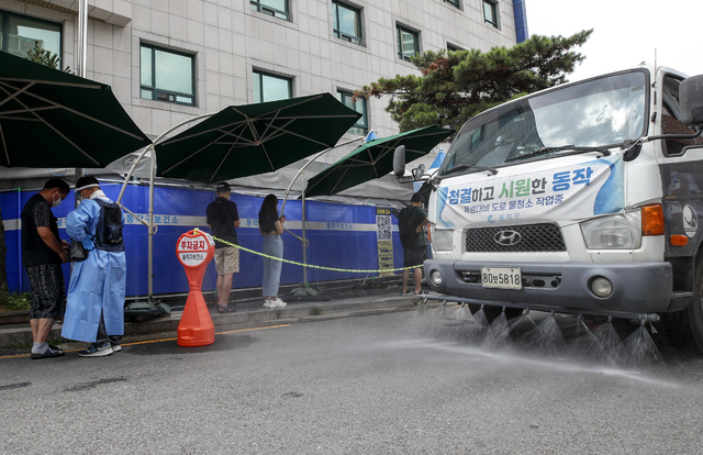 [서울=뉴시스] 서울시는 기후변화로 인한 시민 피해를 최소화하기 위해 폭염 대비 '기후변화 적응 대책'을 적극적으로 추진한다고 19일 밝혔다. 사진은 지난해 서울 동작구보건소에 설치된 코로나19 선별진료소 앞에서 더위를 식히기 위해 살수차가 물을 뿌리고 있다. (사진=뉴시스DB) photo@newsis.com