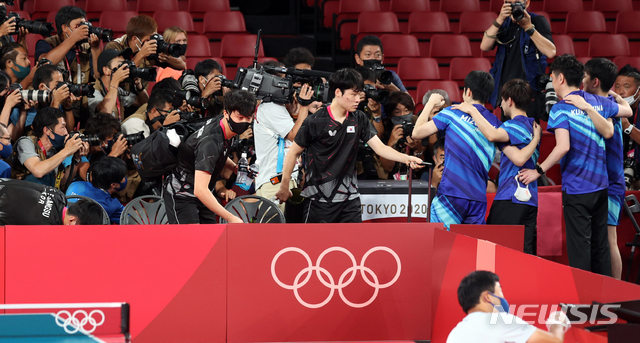 [도쿄(일본)=뉴시스] 최진석 기자 = 대한민국 남자 탁구 대표팀이 6일 일본 도쿄체육관에서 열린 '2020 도쿄올림픽' 남자 탁구 단체 동메달 결정전 대한민국과 일본의 경기에서 패한 뒤 이동하는 옆으로 일본 선수들이 동메달을 기념하며 포즈를 취하고 있다. 2021.08.06. myjs@newsis.com