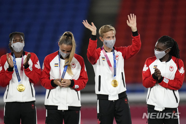 [요코하마=AP/뉴시스] 캐나다는 6일 일본 요코하마 인터내셔널 스타디움에서 열린 스웨덴과의 '2020 도쿄올림픽' 여자축구 결승전에서 연장전 끝에 승리했다. 퀸(가운데 오른쪽)은 역사상 최초로 금메달을 획득한 트랜스젠더 선수가 됐다. 2021.08.06.