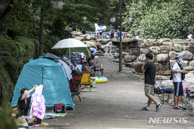 [과천=뉴시스] 정병혁 기자 = 지난 7일 오후 경기 과천시 과천향교 인근 계곡을 찾은 시민들이 그늘에서 더위를 식히고 있다. 2021.08.07. jhope@newsis.com