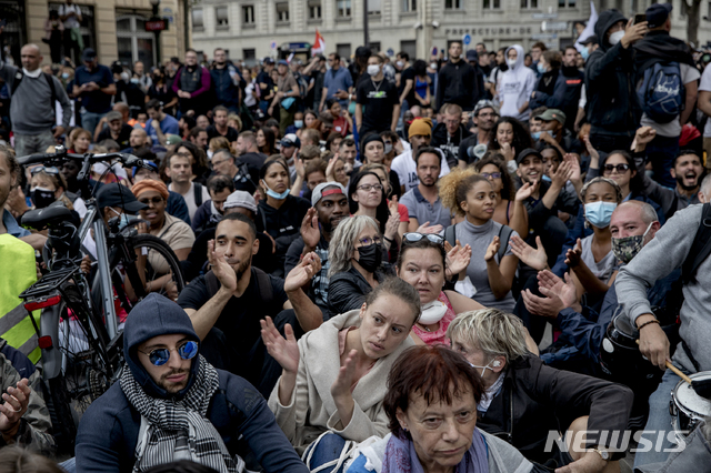 [AP/뉴시스] 7일 프랑스 파리에서 백신접종 완료가 표시된 통행증 제도에 반대하는 시민들이 행진시위가 경찰에 차단되자 연좌 농성을 벌이고 있다. 통행증이 있어야 식당, 공공교통을 이용할 수 있다