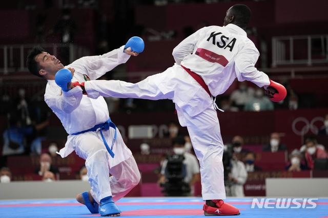[도쿄=AP/뉴시스]7일 도쿄올림픽 공수도 75㎏+급 남자 대련 결승전에서 이란의 사자드 간자데(왼쪽)가 사우디아라비아의 타렉 하메디의 발차기에 얼굴을 맞아 쓰러지고 있다. 간자데는 의식을 잃고 의무실로 실려갔지만 하메디의 발차기가 위험한 공격으로 선언돼 실격 처리되면서 반칙승으로 금메달을 따냈다. 2021.8.8