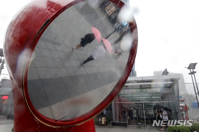 [서울=뉴시스] 김병문 기자 = 제9호 태풍 ‘루핏’이 밤부터 최근접할 것으로 예보된 지난 8일 오후 서울 서대문구 신촌거리에서 시민들이 비를 피하고 있다. 2021.08.08. dadazon@newsis.com