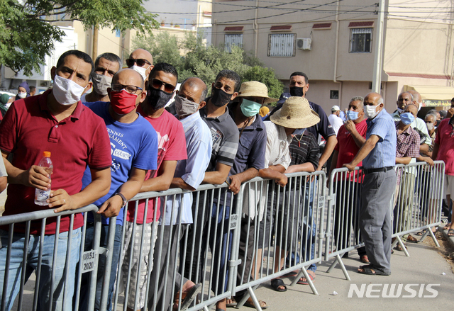 [튀니스=AP/뉴시스] 8일(현지시간) 튀니지 수도 튀니스 외곽의 한 마을에 있는 학교에 마련된 코로나19 백신 접종소에서 주민들이 백스제브리아(아스트라제네카) 백신을 접종하기 위해 대기하고 있다. 튀니지가 급증하는 코로나19 사태에 직면하면서 40세 이상 시민 100만여 명을 일일 접종 목표로 삼고 최대 규모의 백신 접종에 착수했다. 튀니지는 지금까지 하루 3~6만 명에게 백신을 접종했었다. 2021.08.09.