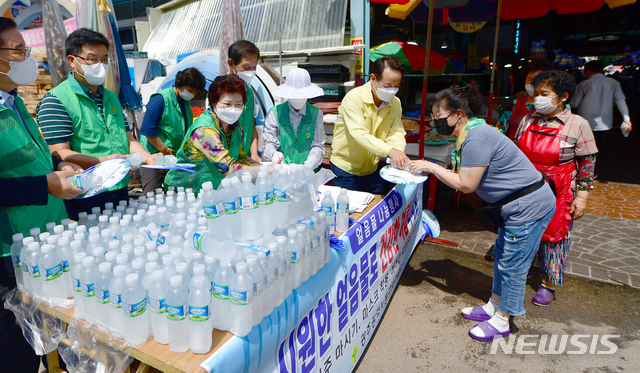[광주=뉴시스] 류형근 기자 =&nbsp; 동구청 직원들이 시장 상인과 이용객들에게 얼음 생수를 나눠주고 있다. 2021.08.10. hgryu77@newsis.com