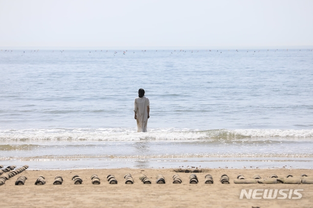 [서울=뉴시스] 바다에 조선시대 기와 수백장을 드로잉, 퍼포먼스를 하고 있는 현대미술가 지나 손. 사진=지나손 제공, 2021.8.11photo@newsis.com