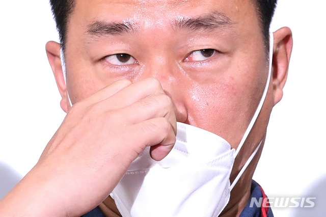 [서울=뉴시스] 김병문 기자 = 양경수 전국민주노동조합총연맹 위원장이 지난 11일 오전 서울 중구 민주노총에서 구속 전 피의자 심문(영장실질심사) 불출석 등에 대한 입장을 밝히며 마스크를 고쳐 쓰고 있다. 양 위원장은 서울 도심에서 불법 집회를 주도한 혐의를 받고 있다. 2021.08.11. dadazon@newsis.com