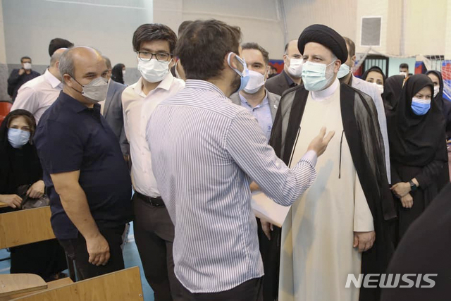 [테헤란=AP/뉴시스] 세예드 에브라힘 라이시(오른쪽) 이란 신임 대통령이 10일(현지시간) 이란 테헤란의 한 코로나19 백신 접종소를 전격 방문해 한 남성의 말을 듣고 있다. 이란은 최근 코로나19 일일 확진자 수가 4만 명에 육박하는 등 확산세가 급등하고 있다. 2021.08.11.