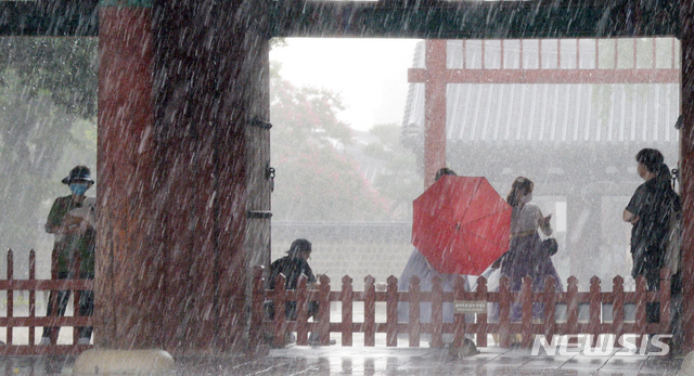 [전주=뉴시스] 김얼 기자 = 전북 전주시에 갑작스러운 집중호우가 내리기 시작한 12일 오후 전주한옥마을 경기전 처마 밑에서 관광객들이 비를 피하고 있다. 2021.08.12. pmkeul@newsis.com