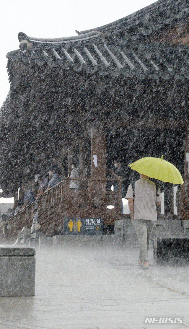 [전주=뉴시스] 김얼 기자 = 전북 전주시에 갑작스러운 집중호우가 내리기 시작한 12일 오후 전주한옥마을 남천교 청연루 처마 밑에서 관광객들이 비를 피하고 있다. 2021.08.12. pmkeul@newsis.com