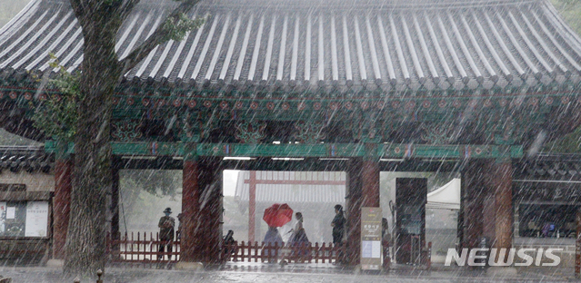 [전주=뉴시스] 김얼 기자 = 전북 전주시에 갑작스러운 집중호우가 내리기 시작한 12일 오후 전주한옥마을 경기전 처마 밑에서 관광객들이 비를 피하고 있다. 2021.08.12. pmkeul@newsis.com