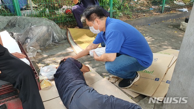 [서울=뉴시스] 임명희 광야교회 목사가 12일 서울 영등포구 쪽방촌에서 노숙자를 돕고 있다. 2021.08.14 photo@newsis.com