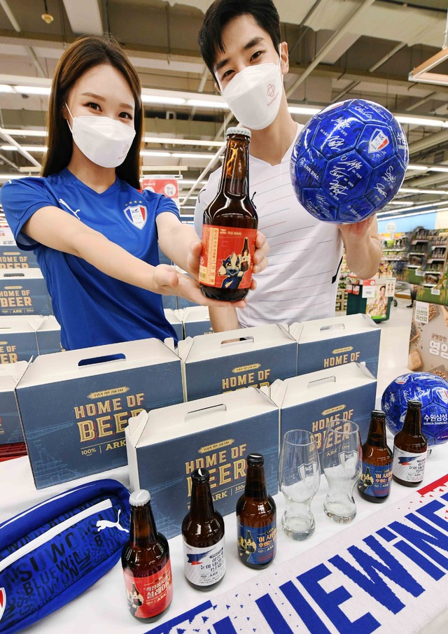 [서울=뉴시스] 13일 경기도 홈플러스 동수원점에서 모델들이 '수원삼성블루윙즈 병맥주잔 기획팩'을 선보이고 있다. '수원삼성블루윙즈'를 모티브로 한 기획팩은 지난 12일 수원지역 홈플러스 8개점에서 2300개 한정 판매에 돌입했다. (사진=홈플러스 제공) 2021.08.13. photo@newsis.com *재판매 및 DB 금지